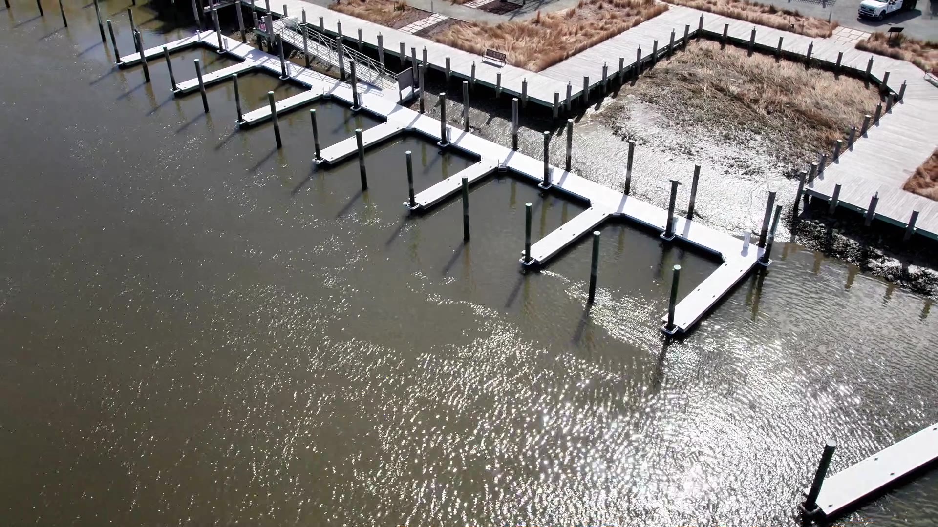 Aerial view of a Hastings Marine Construction work barge and crane among moored boats in a Delmarva marina.