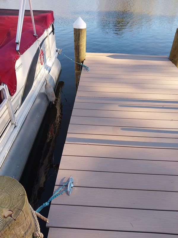 Cleat and piling cap along a PVC-decked dock