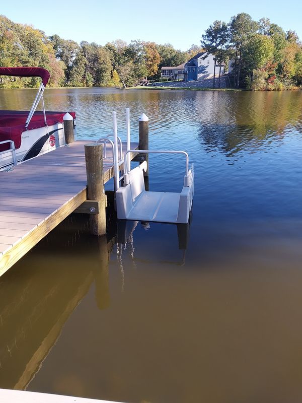 Floating launch with handrails beside a PVC-decked dock