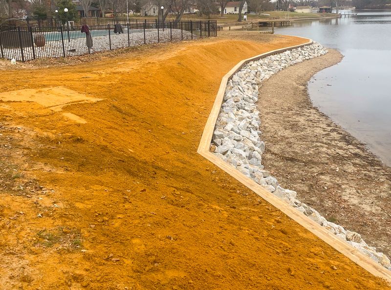 Rip-rap revetment being placed along a graded shoreline